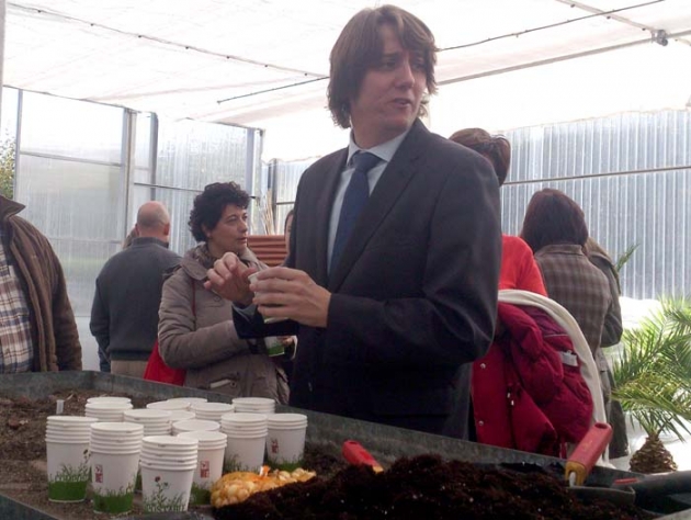 El alcalde siembra una de las semillas en el invernadero