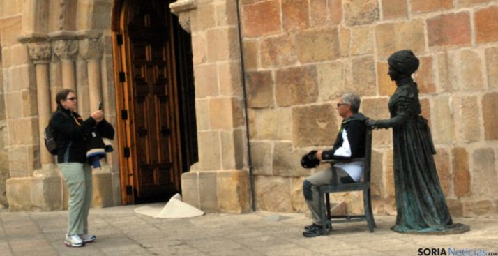 Turistas con la estatua de Leonor al lado de Santa María la Mayor.