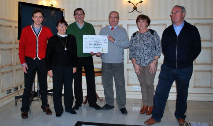 Egido y Crespo sostienen el cheque de la donación.