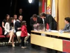 Un niña procede al sorteo ante el alcalde