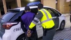 El hondureño, esposado, es introducido en un vehículo de la Guardia Civil. / Sudeleg.
