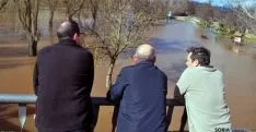 Tres vecinos de Garray observan el río desbordado al paso por la localidad. / SN