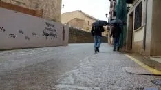 Dos personas se resguardan del granizo./SN