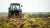 Un tractor arando una parcela agrícola.