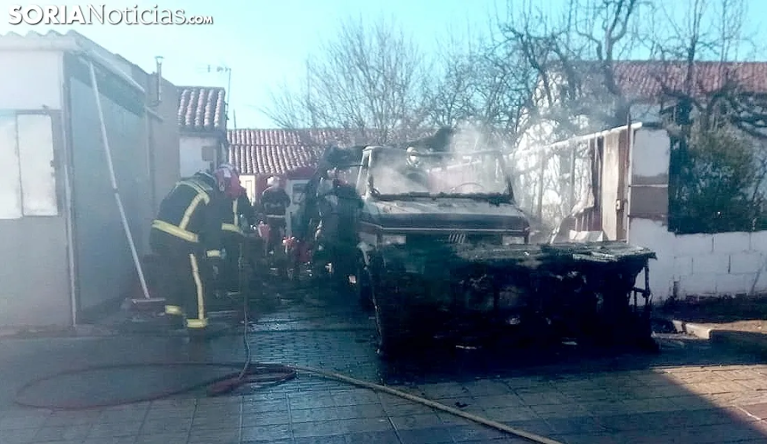 Los bomberos con el vehículo calcinado. /SN