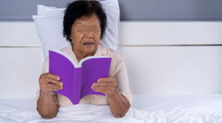 Una paciente lee en su convalecencia hospitalaria. 