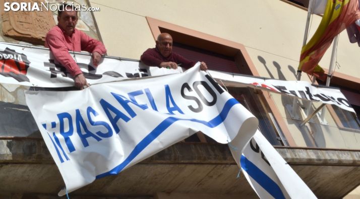 Serrano (izda.) retirando la pancarta reivindicativa de la pasarela. /SN