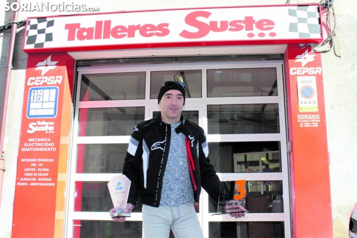 Agustín Álvaro muestra dos trofeos delante del taller que regenta, Talleres Suste. SN