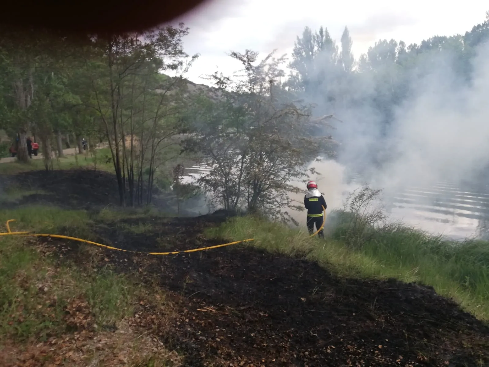 Los bomberos interviniendo en las inmediaciones del río en la capital este lunes. /Ayto