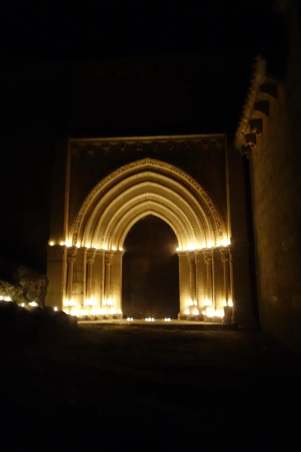 Imagen de las velas encendidas en los arcos de la portada del templo. /DOS