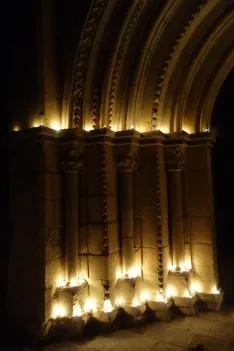 Imagen de las velas encendidas en los arcos de la portada del templo. /DOS