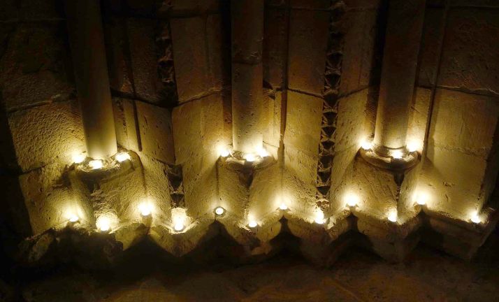 Imagen de las velas encendidas en los arcos de la portada del templo. /DOS