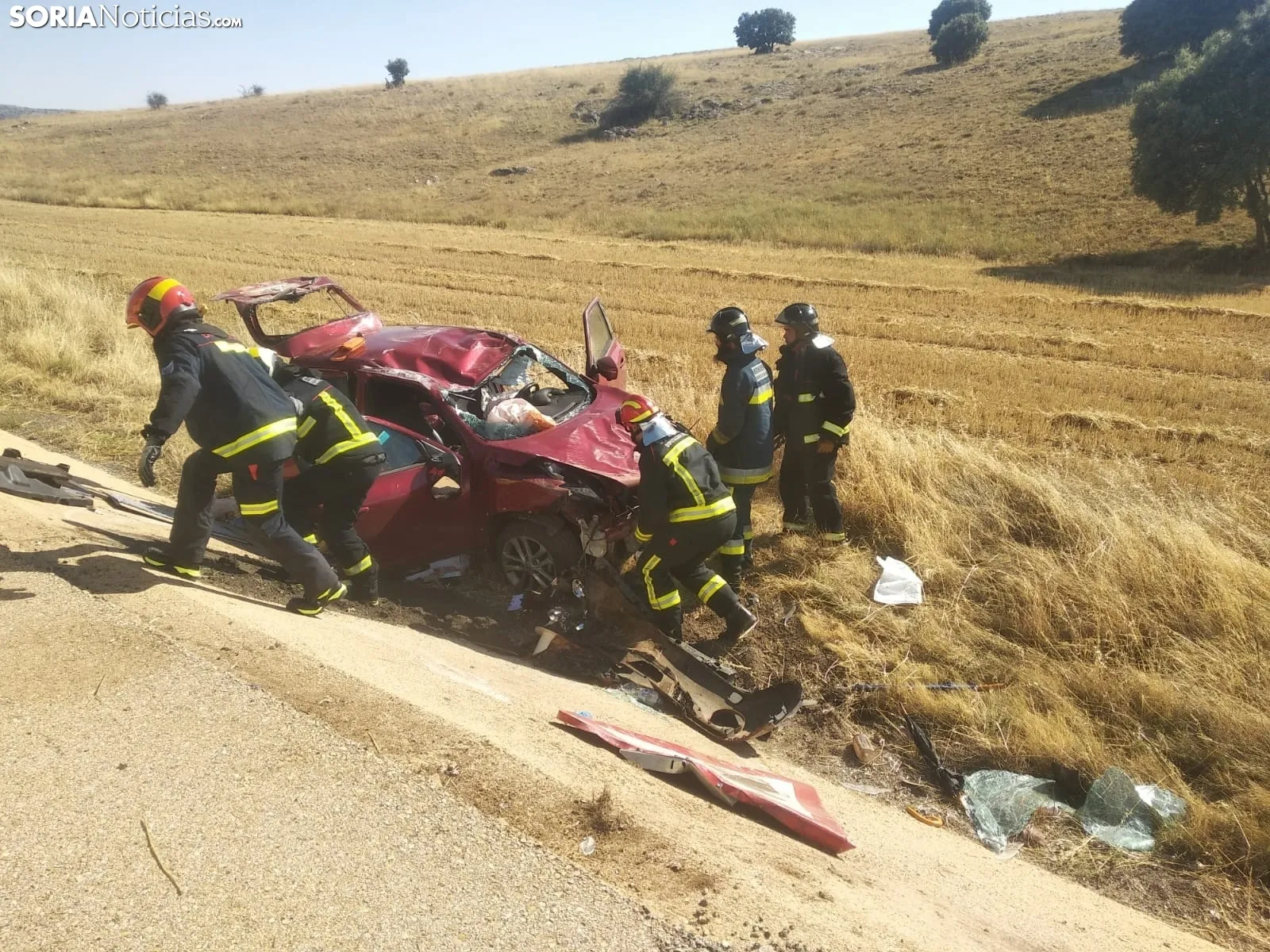 Los bomberos y el vehículo siniestrado. /SN