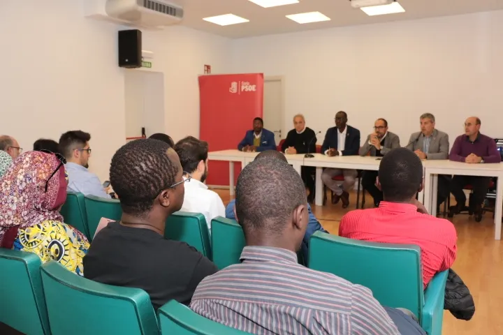 Encuentro de personas migrantes en el que han participado los candidatos al congreso y al senado junto al Secretario ejecutivo de política de Refugiados Luc Andre Diouf. PSOE