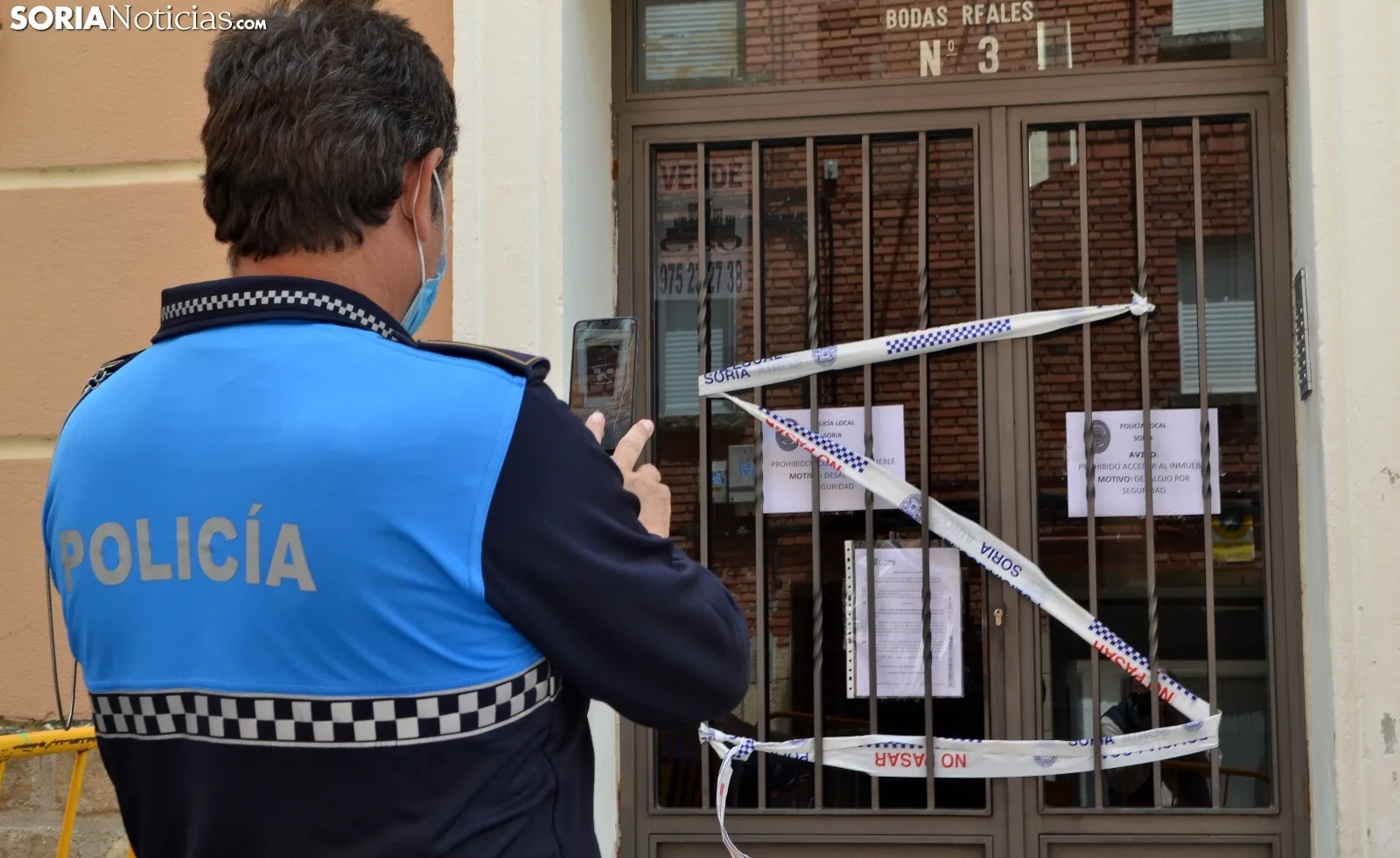 Un agente de la Policía Local ante uno de los portales del edifcio. /SN