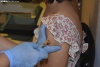 Una joven soriana recibe el primer pinchazo contra el coronavirus.