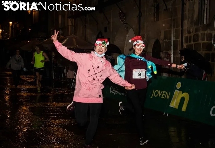 Dos jóvenes sorianas durante la carrera de Navidad del domingo, pasada por agua. 
