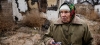 Una mujer en el terreno destruido que fuera su jardín en Ucrania. | ONU Danish Red Cross/Jakob Dall