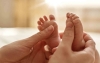 Una madre acaricia los pies de su hijo recién nacido. 
