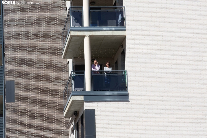 Dos vecinos disfrutando del sol en el balcón.