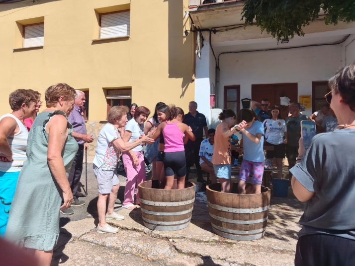 Las niñas lideran el relevo generacional en la pisada de uva de Quintanilla de Tres Barrios